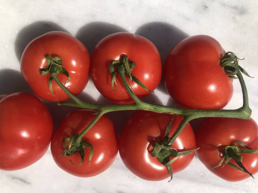 top view of tomatoes on a vine on a marble board