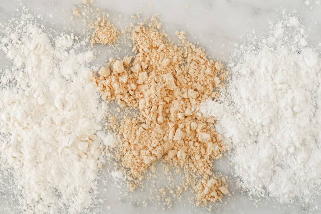 three different kinds of flours on a marble board from top view