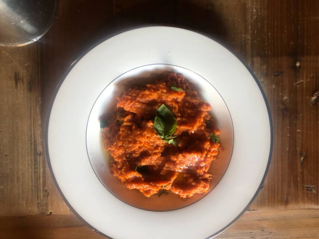 white bowl of pappa al pomodoro on a wooden table.