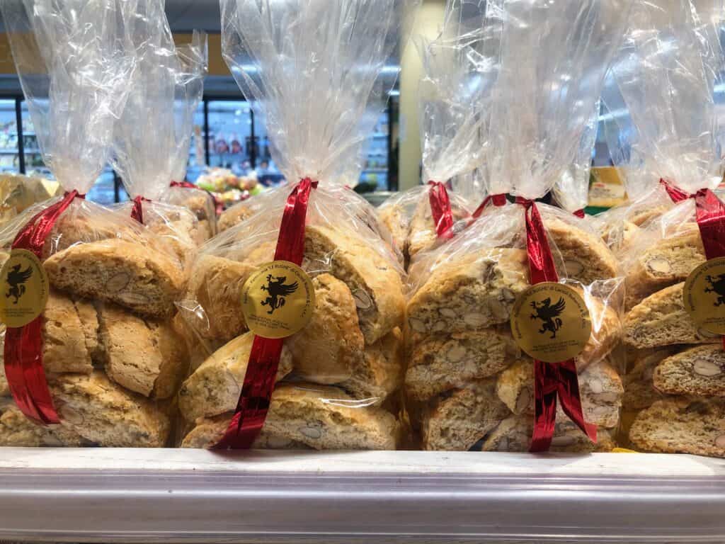 cantucci cookies packaged in plastic with red ribbon sitting on shelf of grocery store