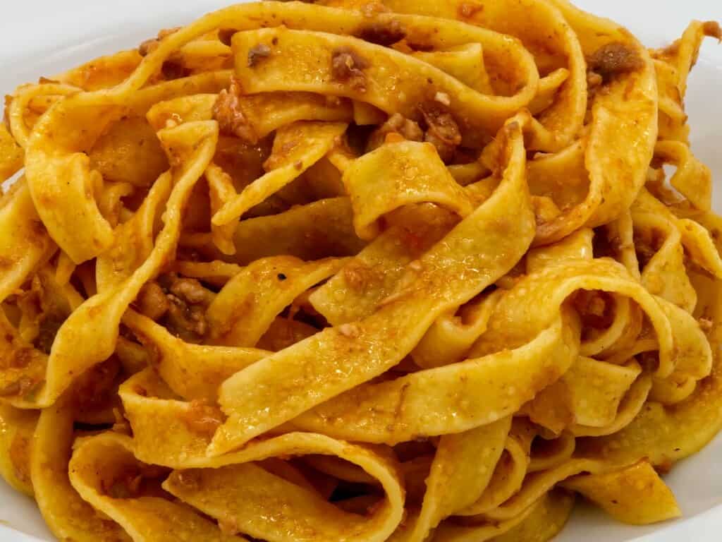 fettuccine / tagliatelle pasta close up covered in rich ragu sauce