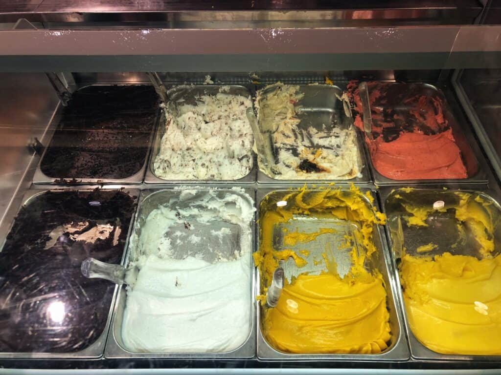 gelato display in the window with various flavors such as chocolate, mango, cream and strawberry