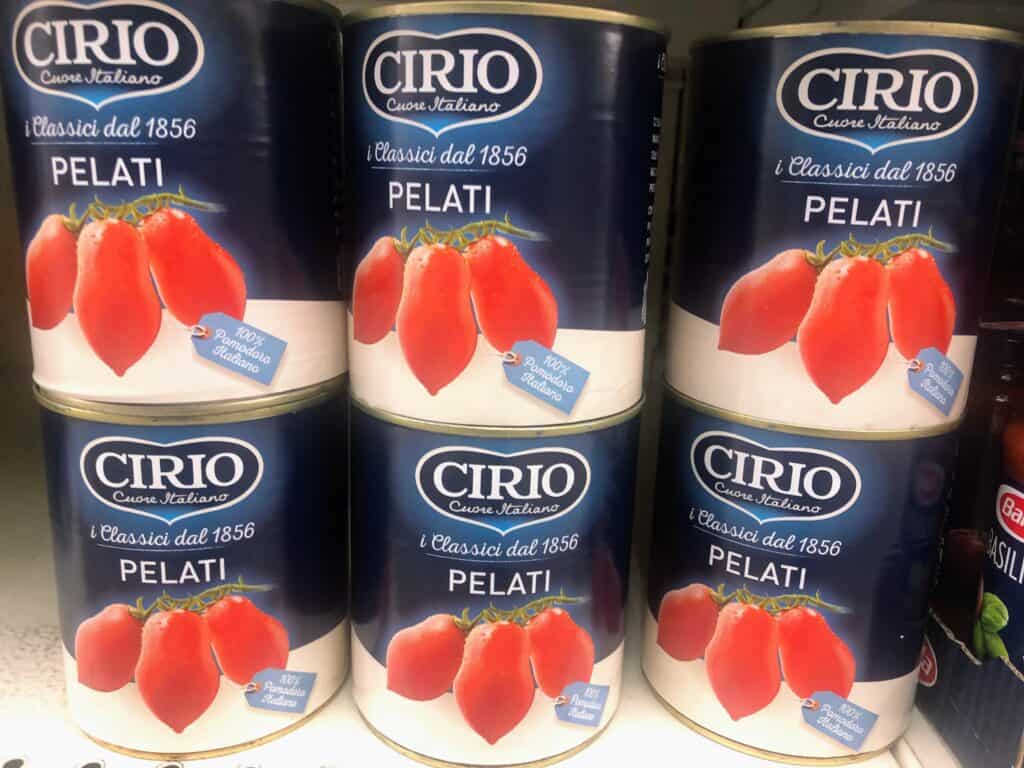close up side view of 6 large cans of tomatoes with a picture of tomatoes on each