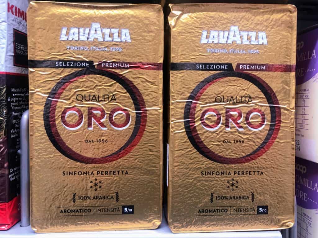 close up of two gold packages of lavazza oro coffee on supermarket shelf