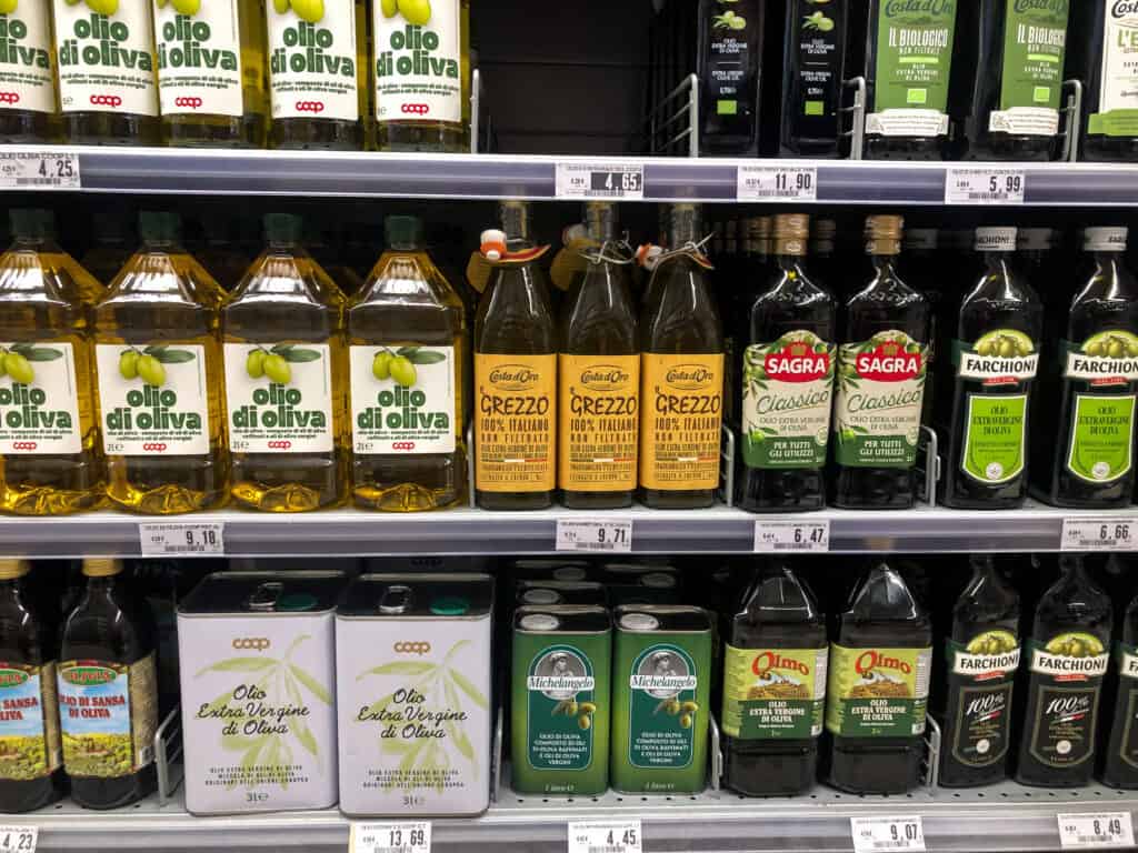Olive oil bottles displayed at a supermarket in Italy.