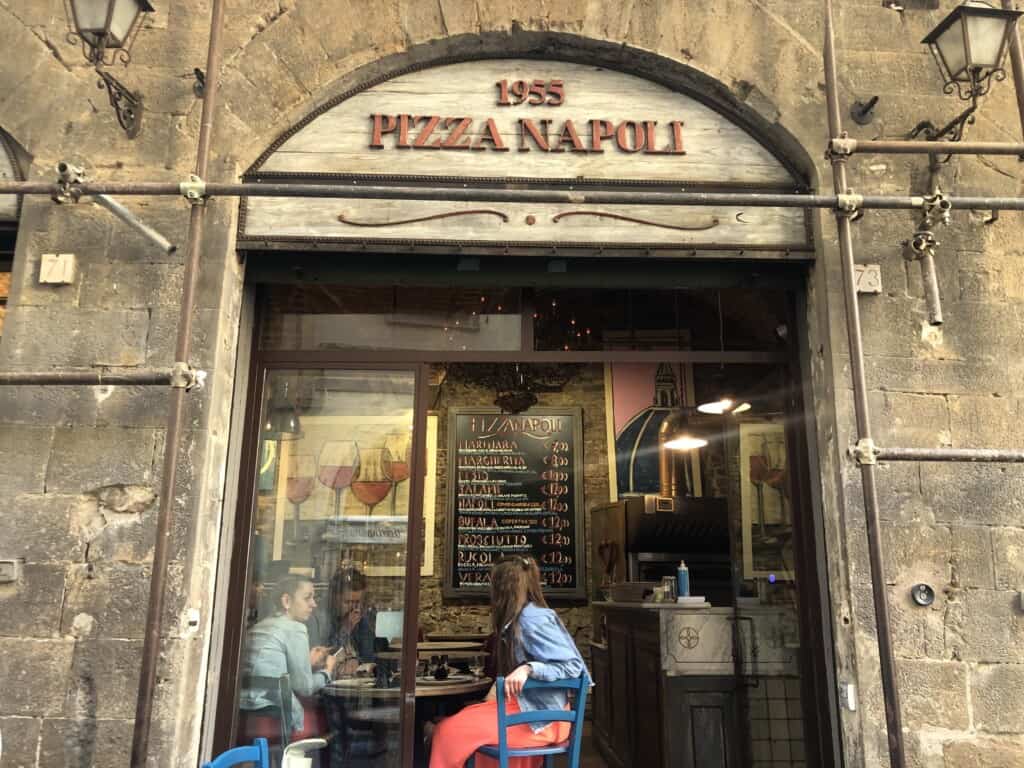 street view of pizzeria napoli with people inside