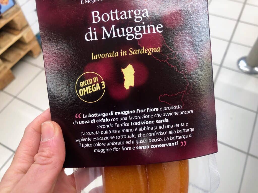hand holding a package of bottarga that is vacuum packed