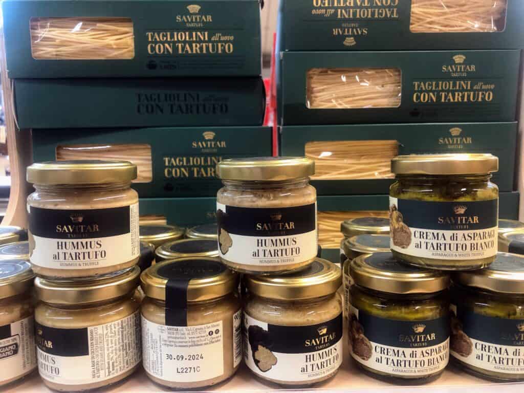 Shelf of jarred and boxed truffle products on a shelf.