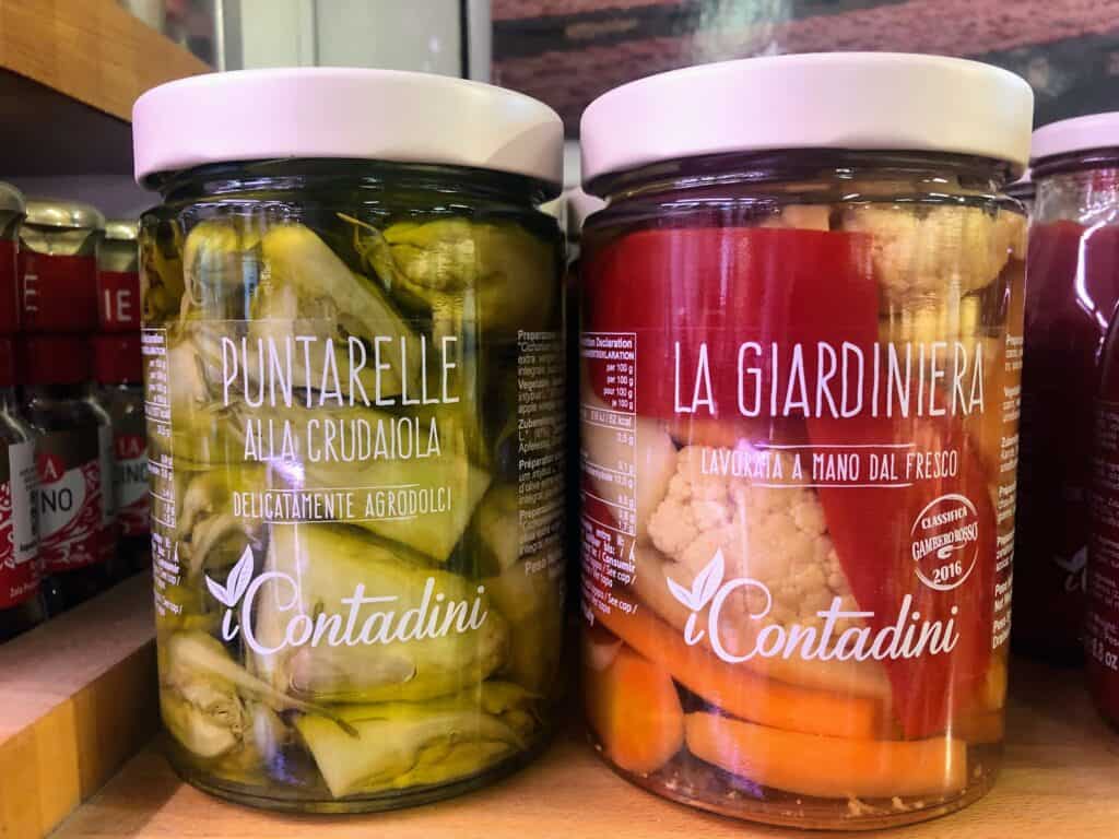 Close up of jars of pickled vegetables at a shop in Italy.