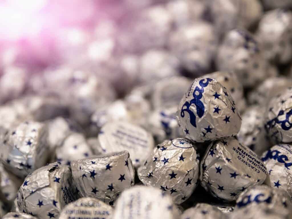 Pile of Perugina baci, a type of Italian chocolate. They are all in silver wrapping with blue stars.