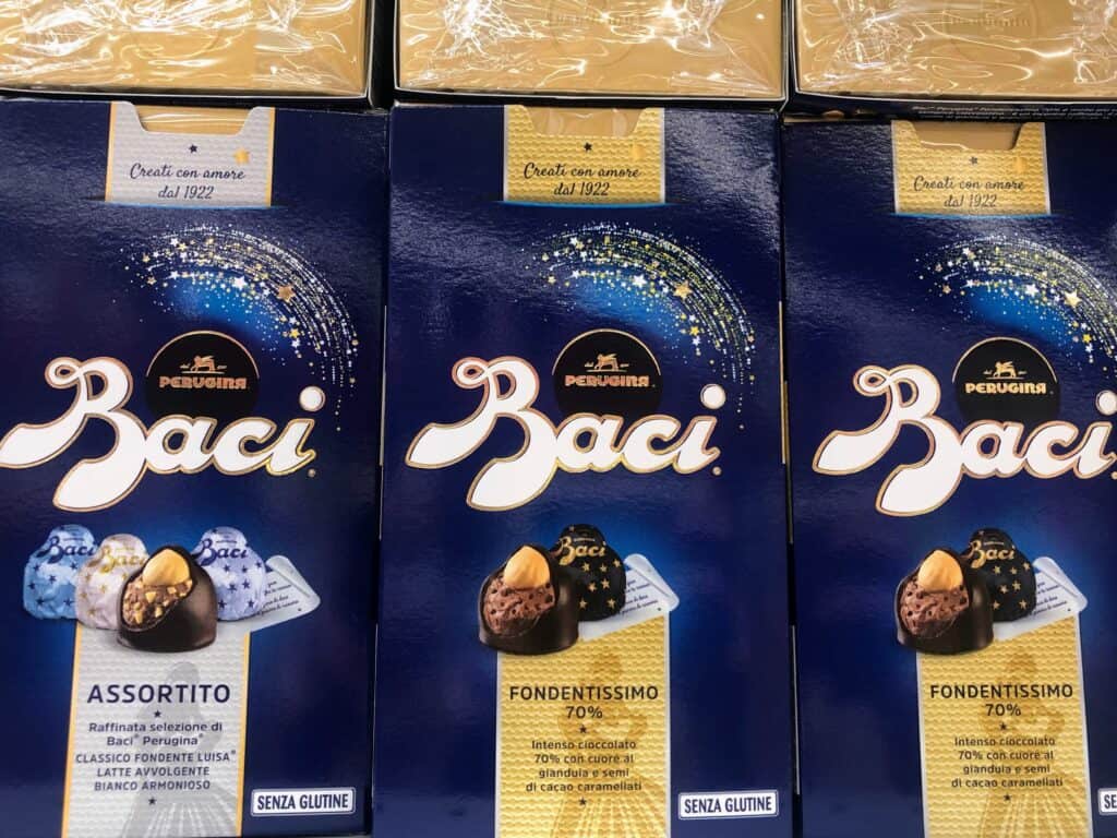 Blue packages of Perugina baci, a favorite Italian chocolate, on display on a grocery store shelf in Italy.