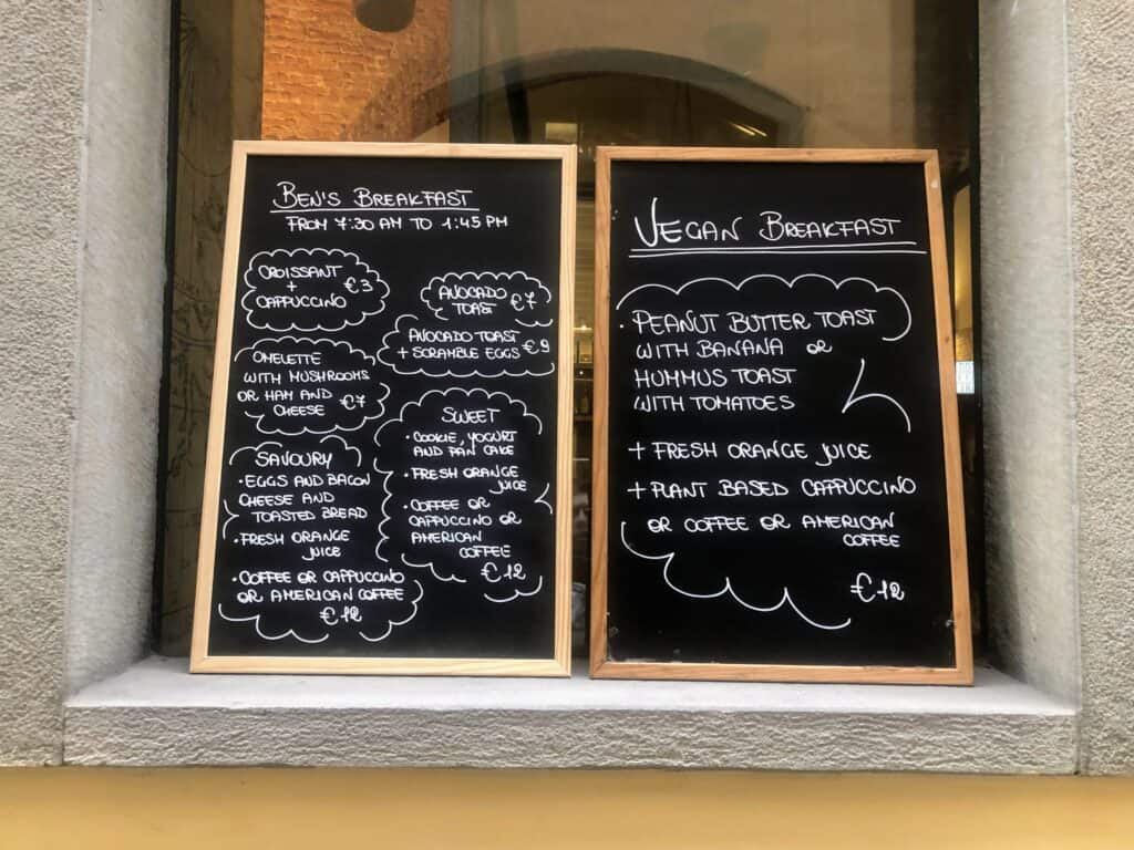 Vegan menu in an in Italian restaurant written on a chalkboard and leaning against a stone windowsill in Italy.  The menu is written in English.