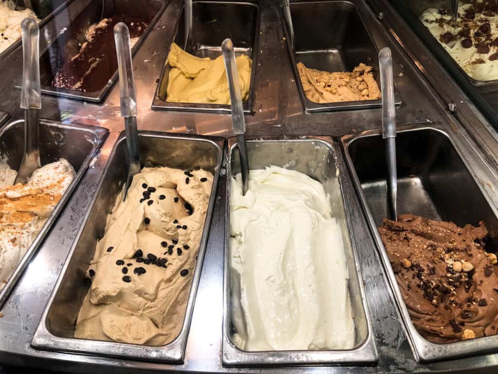 Close up of gelato in metal bins at a gelateria in Italy.