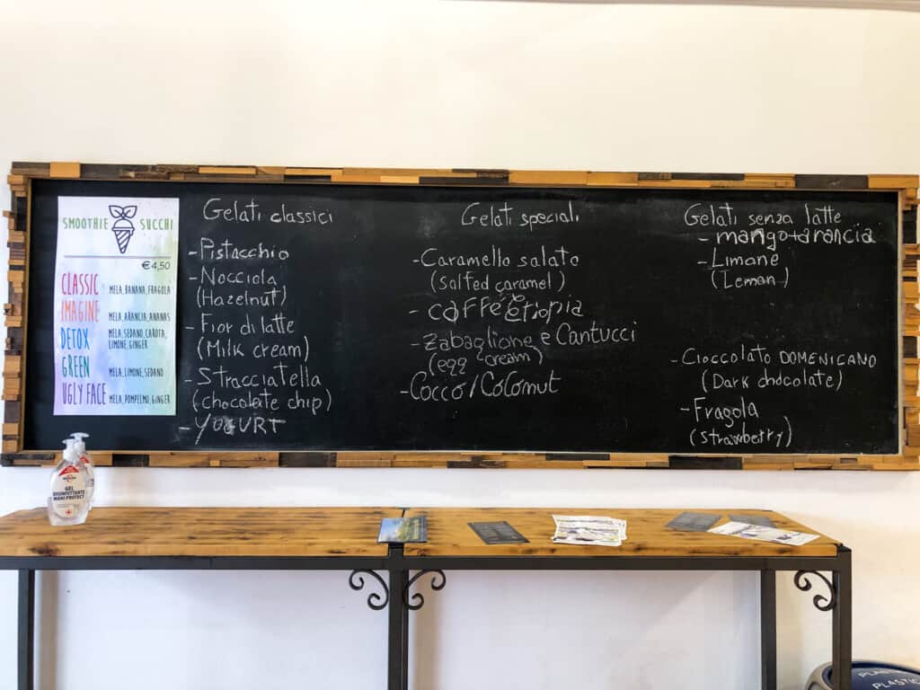 Chalkboard sign with flavors of gelato at a gelateria in Italy.