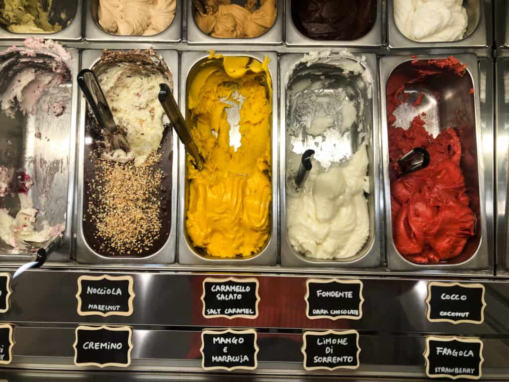 View from above of gelato in metal bins at an Italian gelateria.