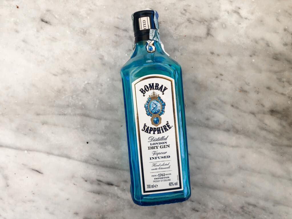 Bottle of Bombay Sapphire gin laying on a marble surface.