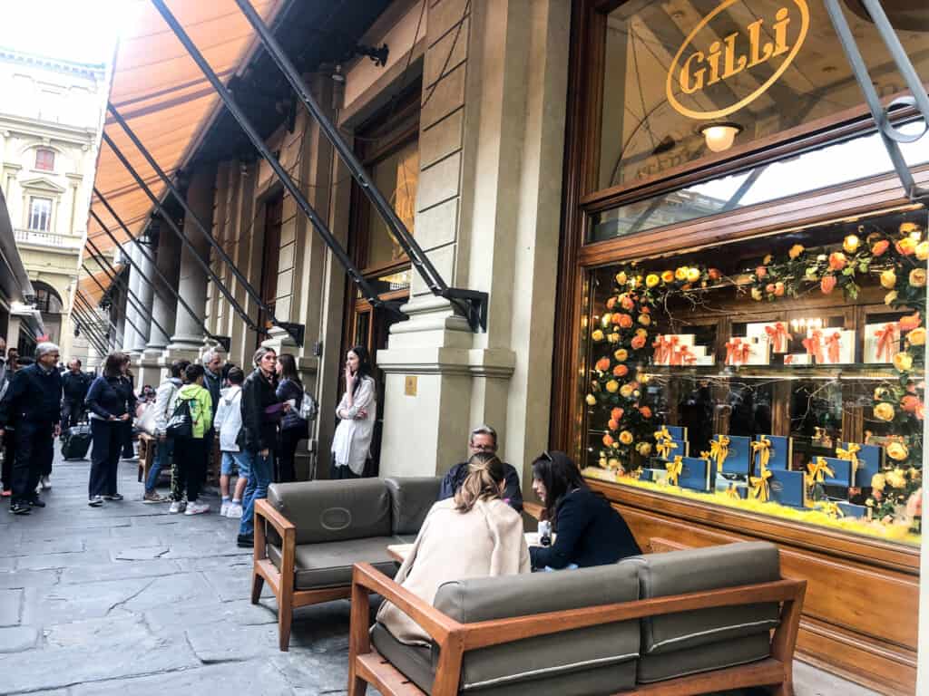 people sitting at a bar in florence on an outdoor couch looking at a menu from side view