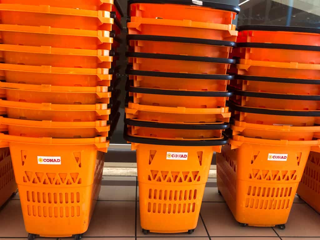 side view close up of orange shopping baskets stacked one on top of another 