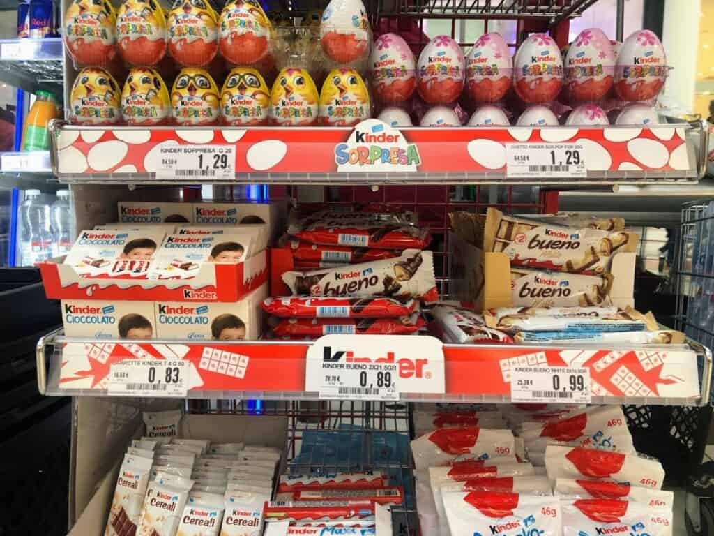 Shelves of Kinder products at a grocery store in Italy.
