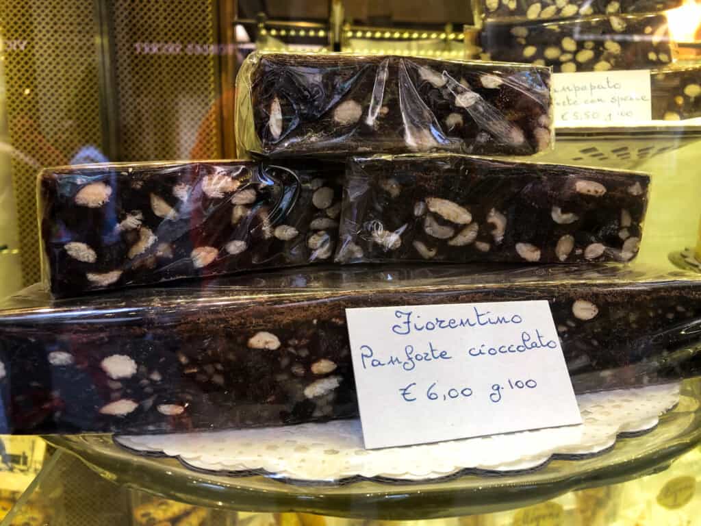 side view of panforte being sold in tuscany with hand written sign indicating what it is and how to store it