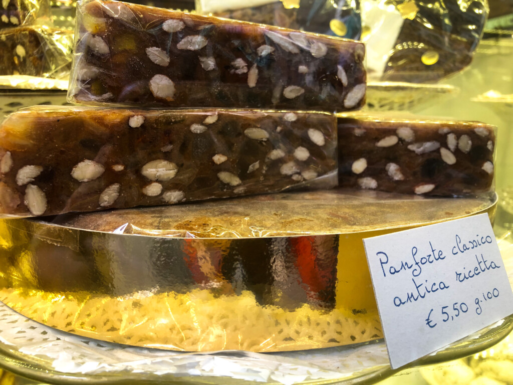 side view of panforte being sold in tuscany with hand written sign indicating what it is and how to store it