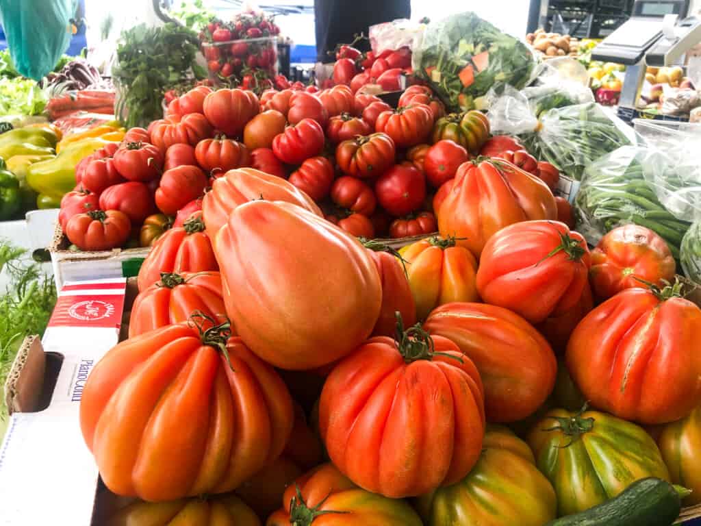 vine ripe tomatoes stacked high outside at a market for sale in italy