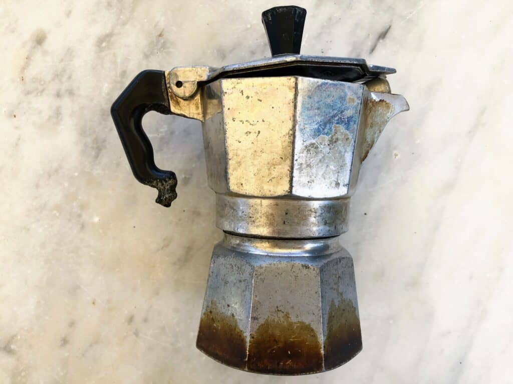 side view of a moka pot on a marble surface close up