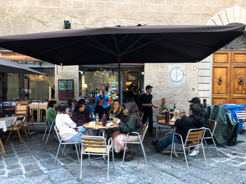 People sitting outside at a bar in Italy enjoying aperitivo.