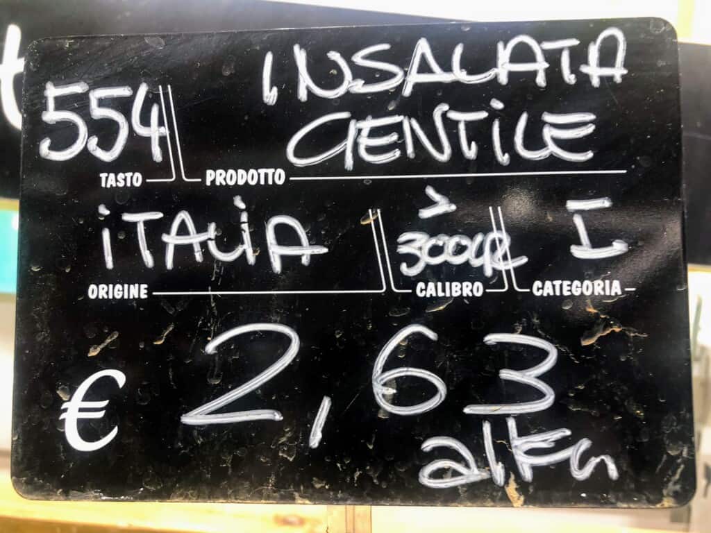 Close up of handwritten sign for lettuce at a grocery store in Italy.