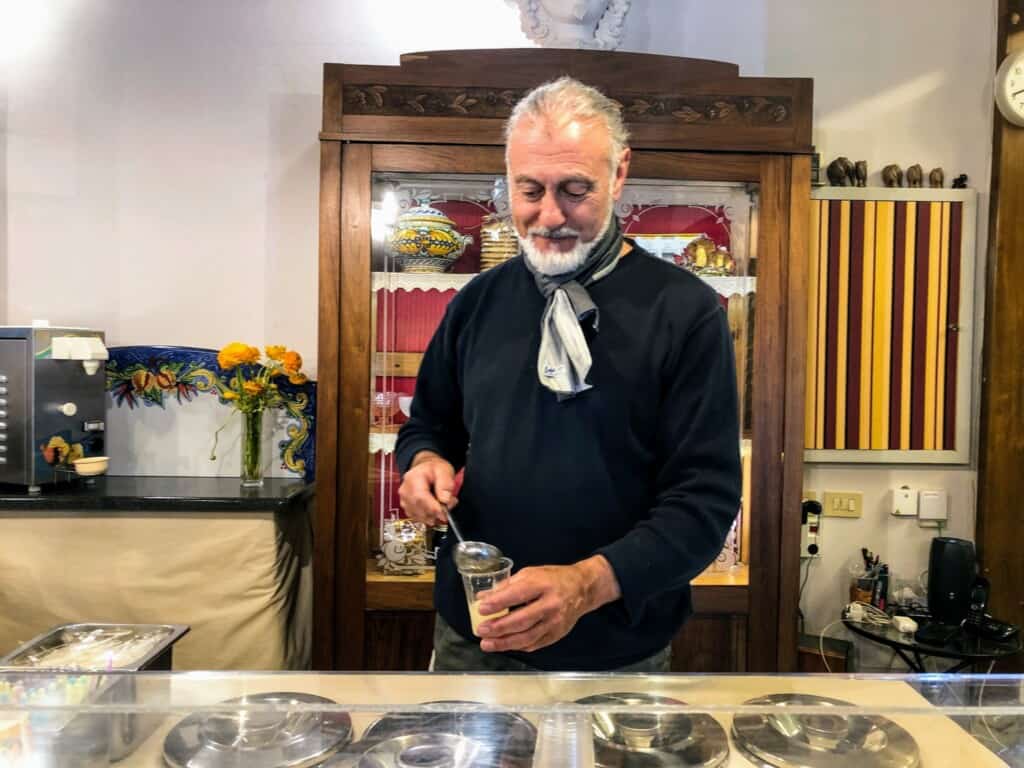 Man serving a granita at Carabè Gelateria in Florence, Italy.