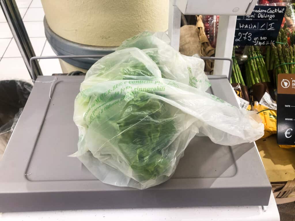 Lettuce in a plastic bag sitting on a grocery store scale in Italy.