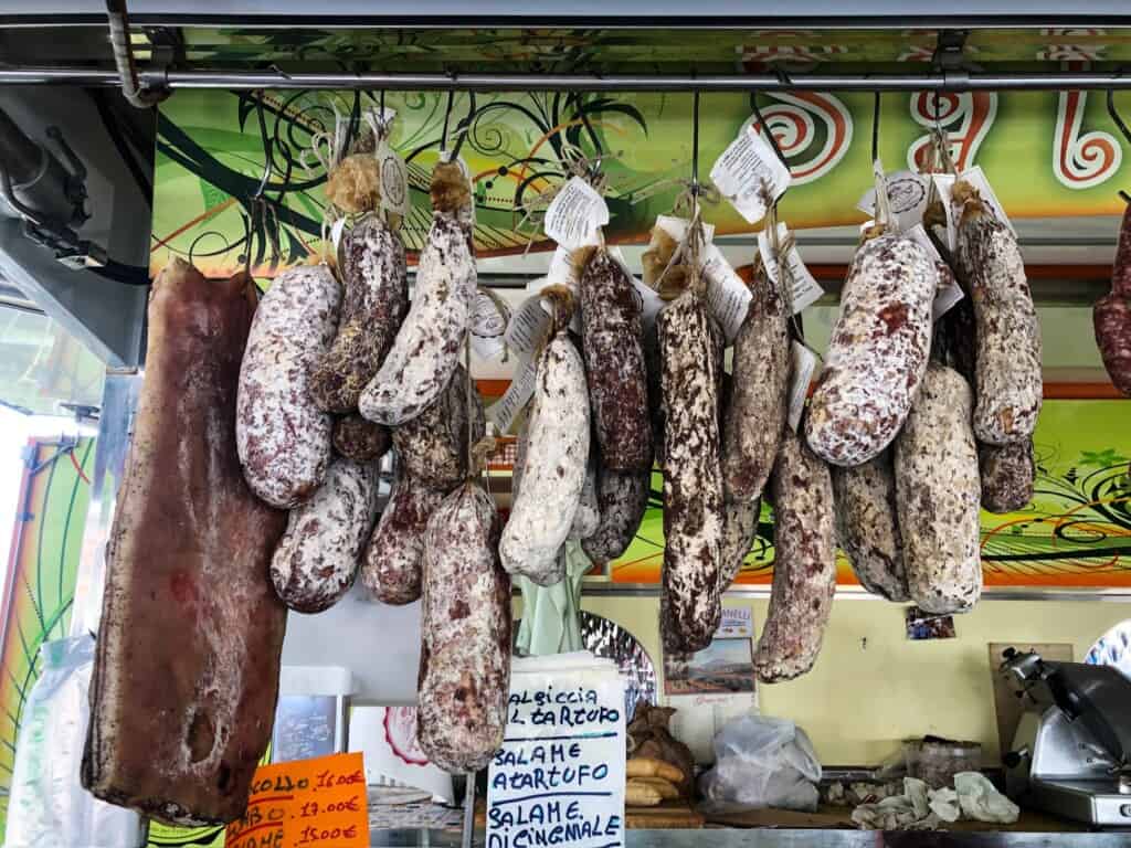 Italian sausages hanging at a market in Italy.