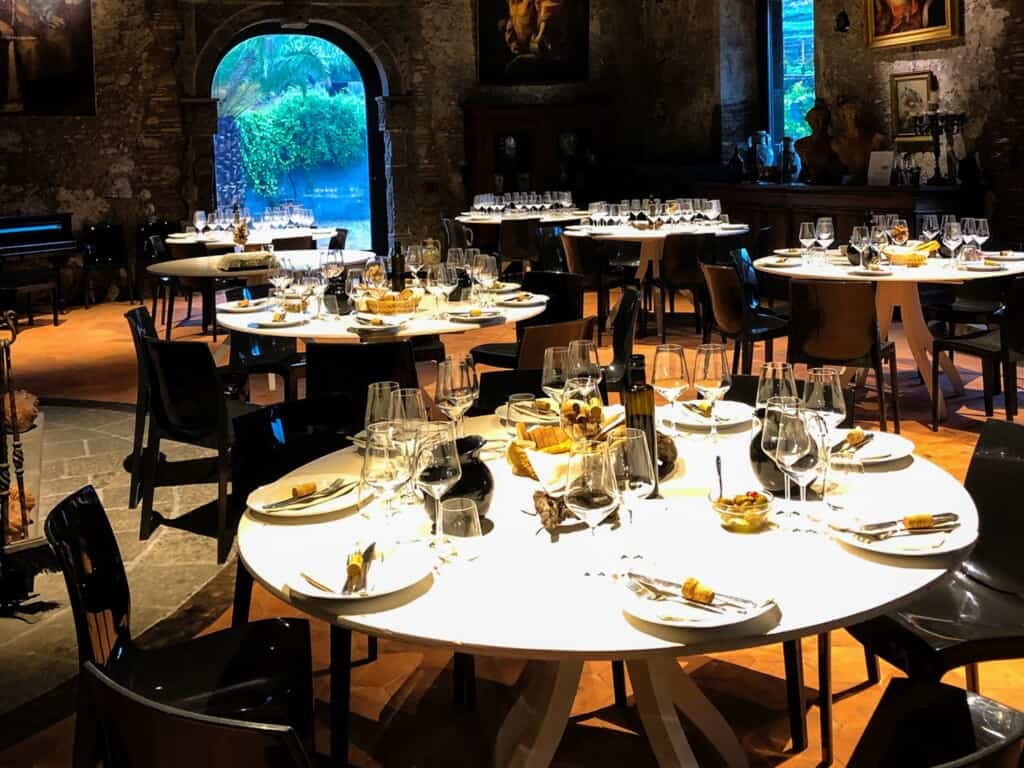 Inside a restaurant in Italy. You can see tables set with silverware, dishes, and wine glasses.