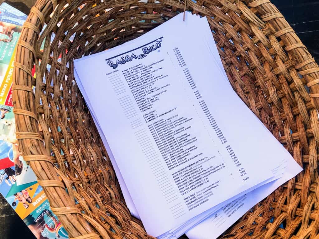Menus for a sagra in Italy are sitting in a basket.
