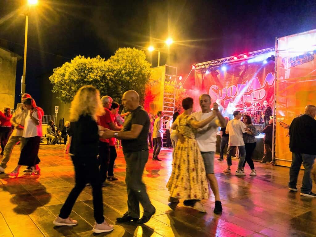 Couples dancing at night at a sagra in Italy.