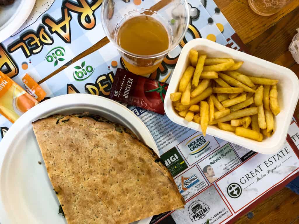 Close up of a sagra meal in Italy - fries, piadina, and beer.