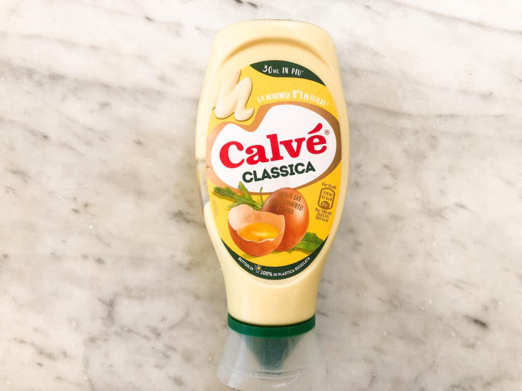 top view of bottle of italian mayonnaise on a marble board