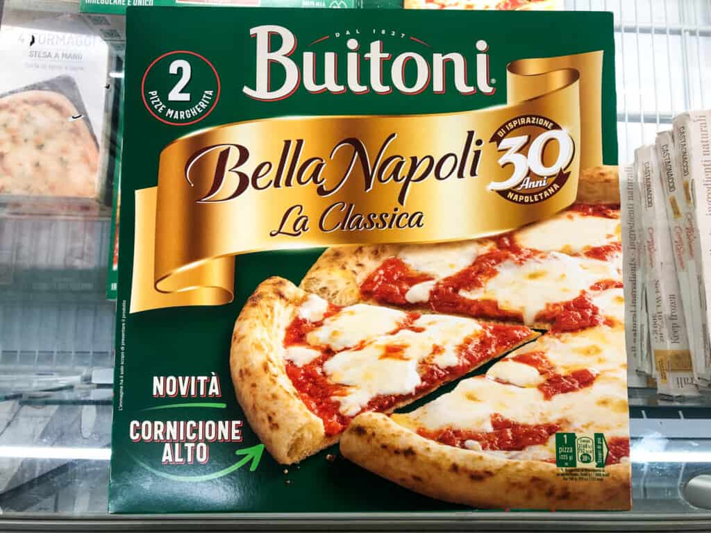 Green box of Buitoni frozen pizza in the freezer at a grocery store in Italy.