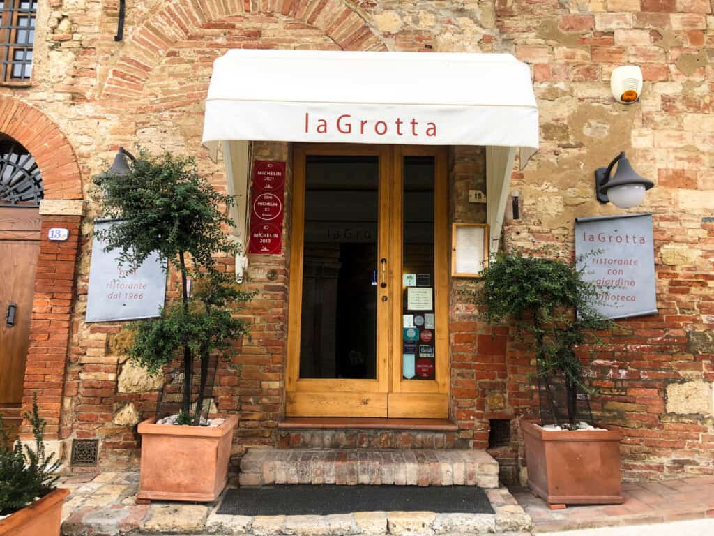 Entrance to La Grotta restaurant in Montepulciano, Italy. There are red Michelin plaques to the left of the door.