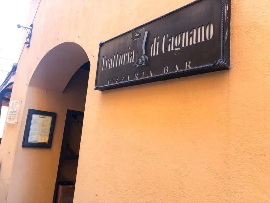 Orange wall with metal sign for Trattoria di Cagnano.