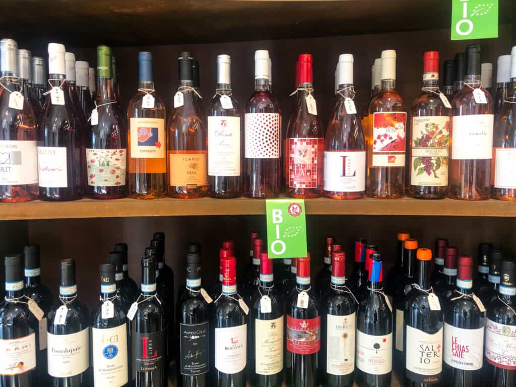 Bottles of rose and red wines on shelves at a shop in Montepulciano, Italy.