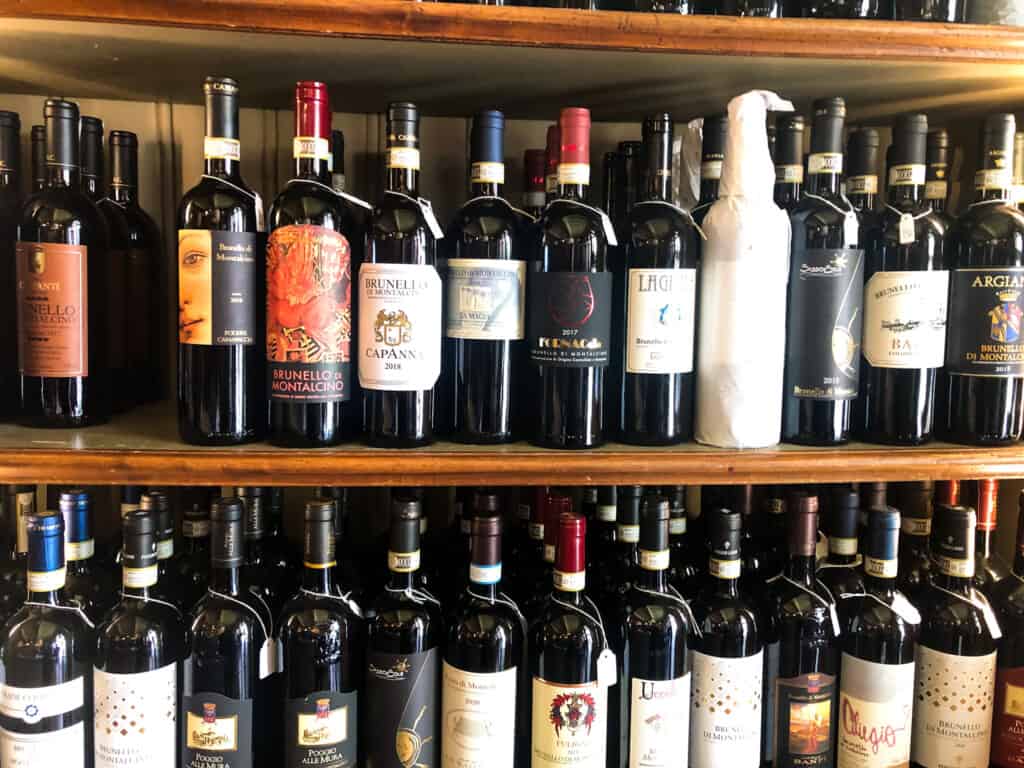 Wine bottles on shelves at a wine shop in Tuscany.