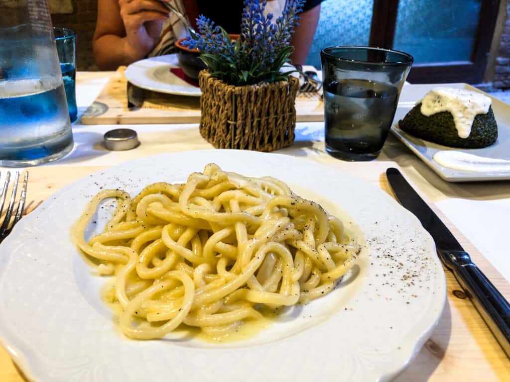 Plate of pici pasta at restaurant in Italy.