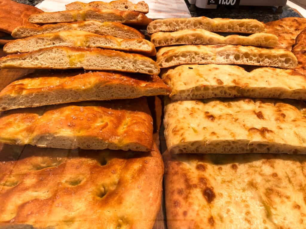 Piles of schiacciata at a grocery store in Tuscany.