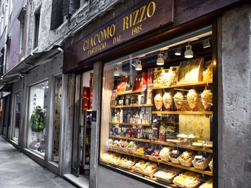 Window display and entrance to Giacomo Rizzo shop in Venice, Italy. In the window are pastas and food souvenirs.