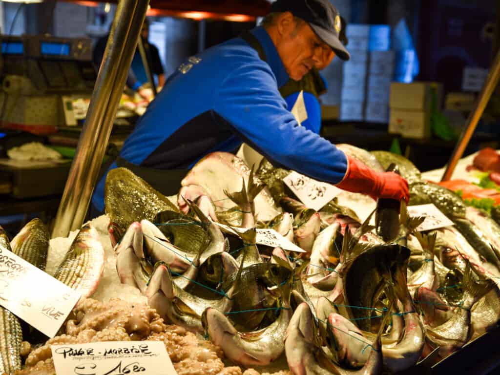 Men work to display freshly-caught fish and seafood on ice at the Rialto Market in Venice, Italy.