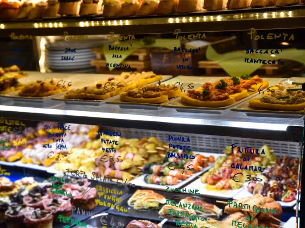 Glass display of cicchetti in Venice, Italy. Some of them are gluten-free, like those made with polenta.