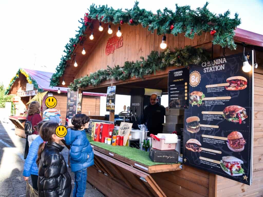 Children wait in line at wooden Chianina beef stall at the Montepulciano Christmas Market.