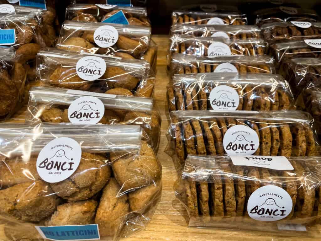 side view of a wooden table filled with pre-packaged cookies from Bonci bakery in Rome. 